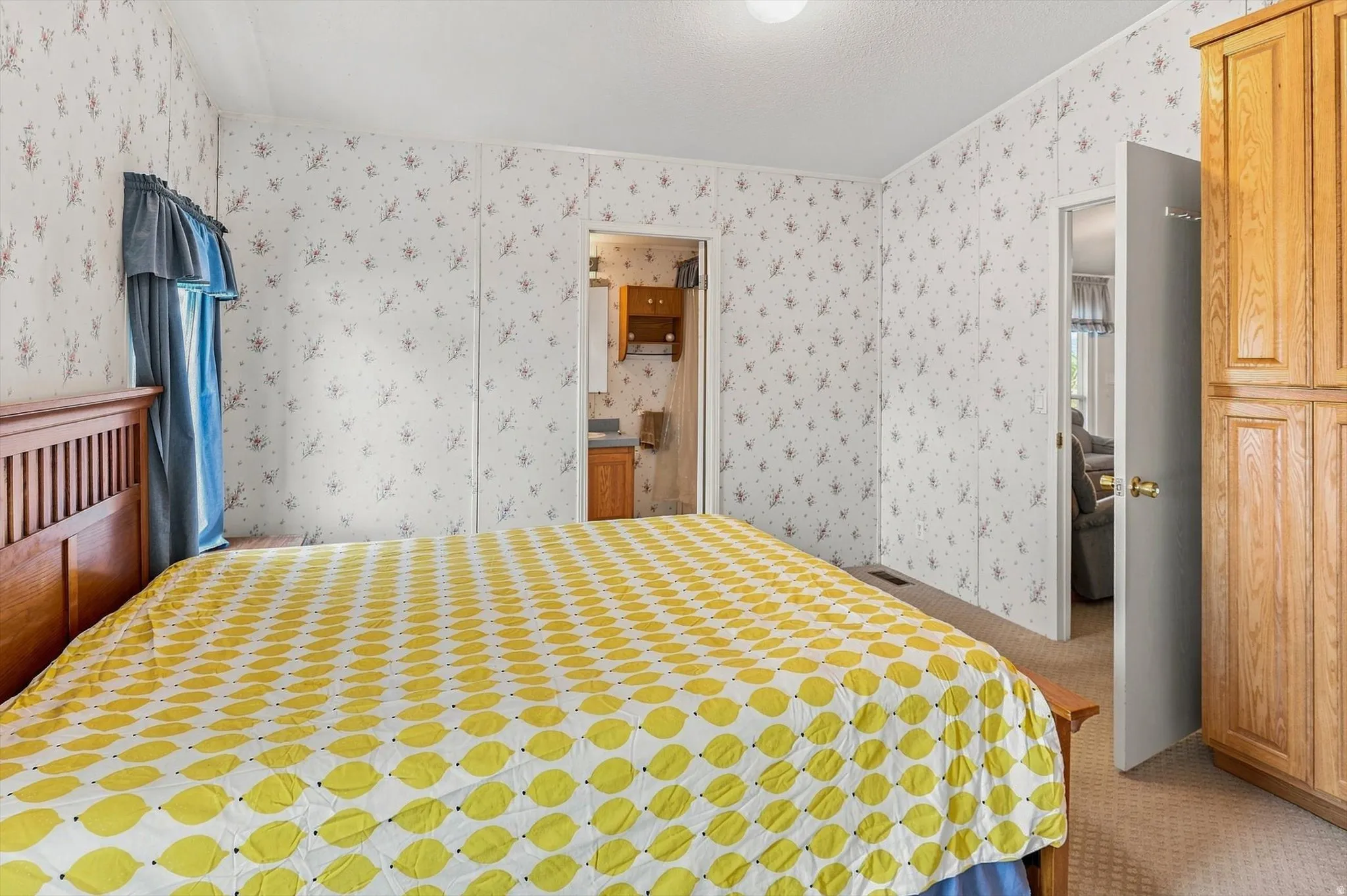 Built-in wood-finish cabinetry, patterned wallpaper, and soft carpeting