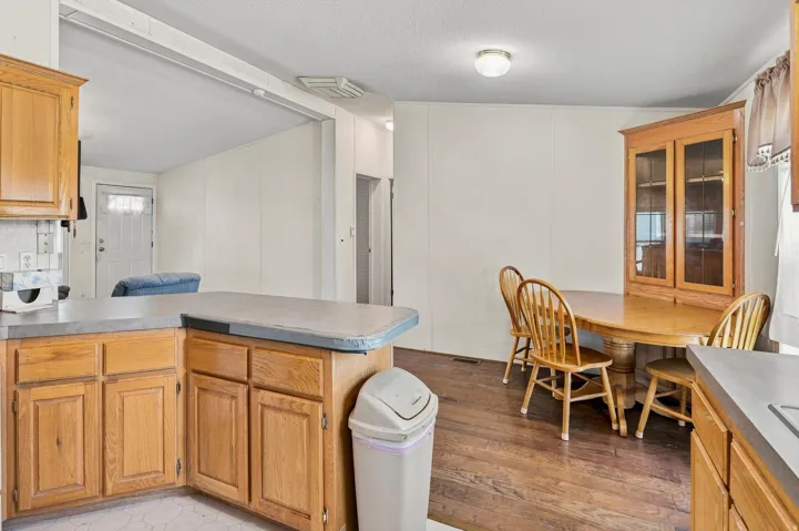 Kitchen area with wood cabinetry and grey countertops