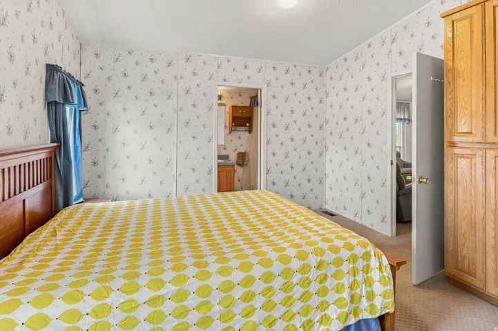 Built-in wood-finish cabinetry, patterned wallpaper, and soft carpeting