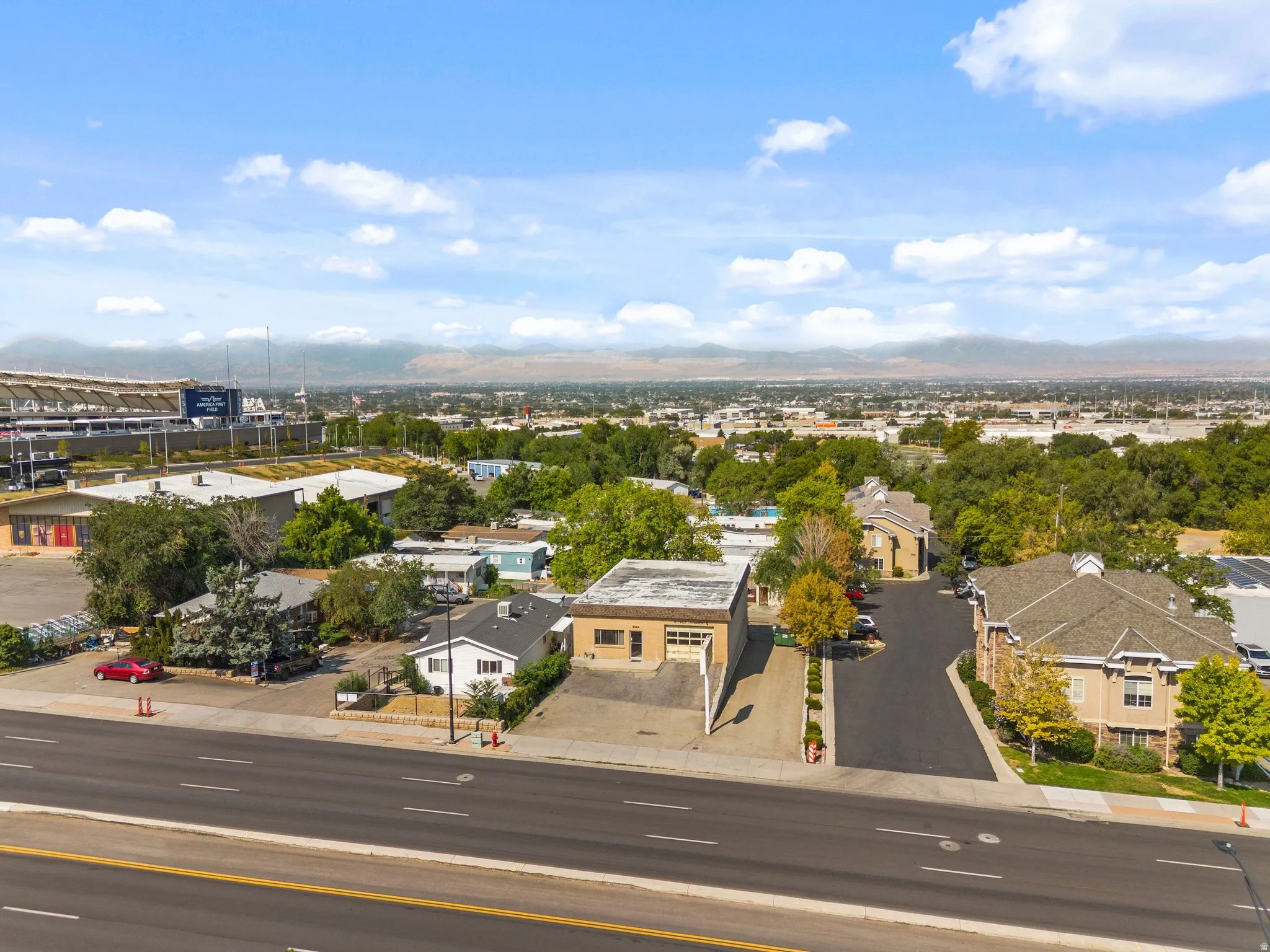 Aerial perspective showcasing residential structures, a stadium, and distant mountains