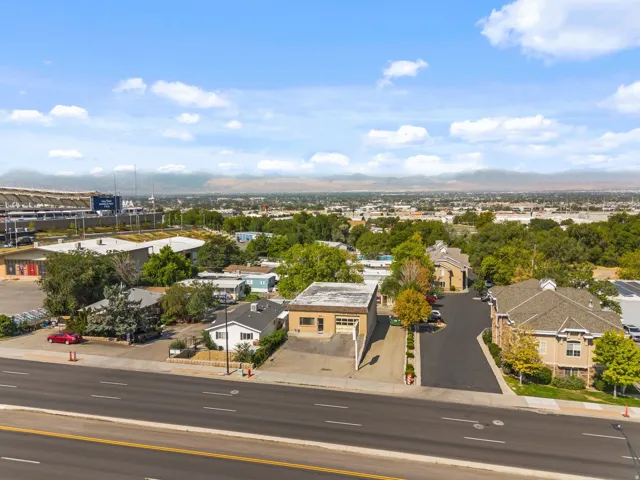 Aerial perspective showcasing residential structures, a stadium, and distant mountains