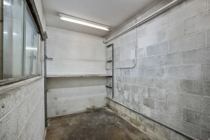 Concrete block walls with utility piping, a built-in shelf, and strip lighting