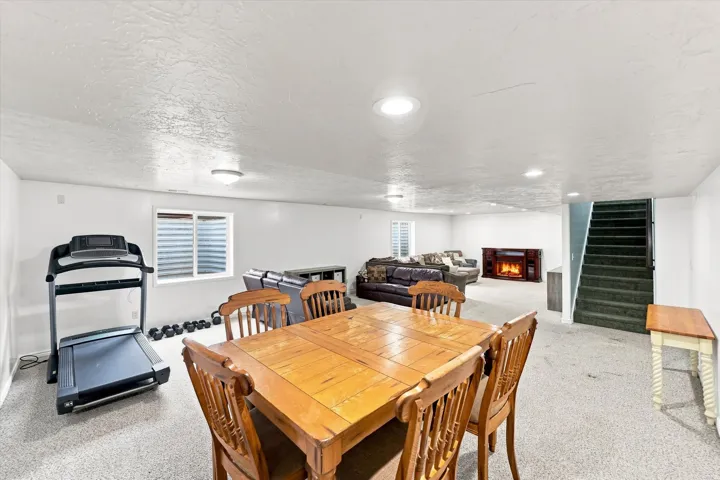 Expansive carpeted room with recessed lighting.  ***Electric fireplace is excluded***