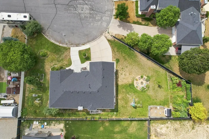 Asphalt shingle roofing, paved driveway, mature trees, fenced backyard, circular cul-de-sac