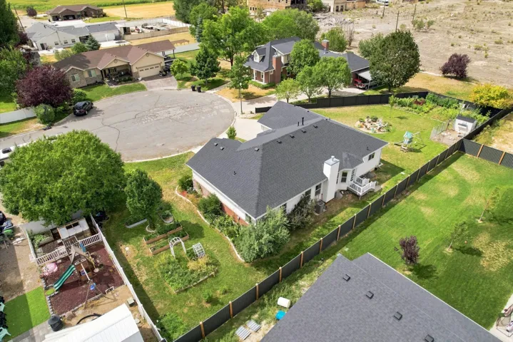 Expansive property featuring a dark shingle roof, white exterior siding, and a fenced backyard