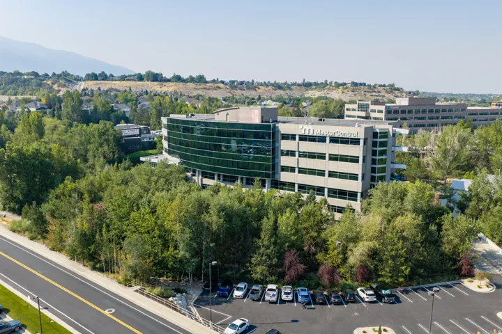 Modern multi-story office building featuring contemporary glass and metal facade with horizontal striping detail