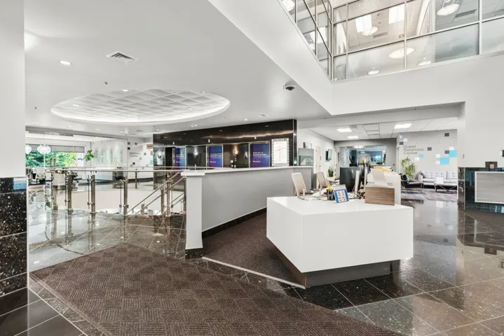 Spacious reception area with polished stone flooring and a white reception desk