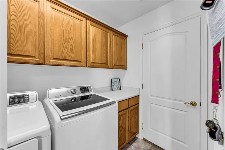 Laundry area featuring wood cabinetry, a white countertop, and tile flooring