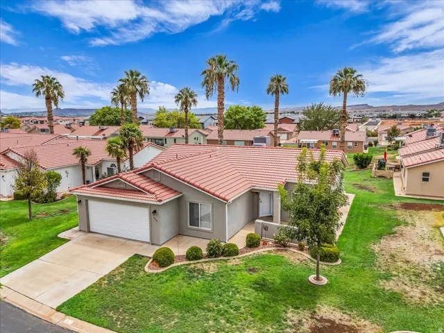 Single-story residence with a stucco exterior, concrete driveway, attached garage, and tile roof