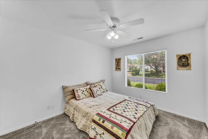 Recessed window with blinds, ceiling fan with integrated lighting, and carpeted flooring