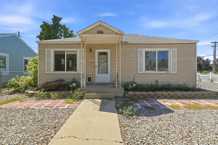 Bungalow-style residence featuring a covered front entry, light-toned siding, and a concrete pathway