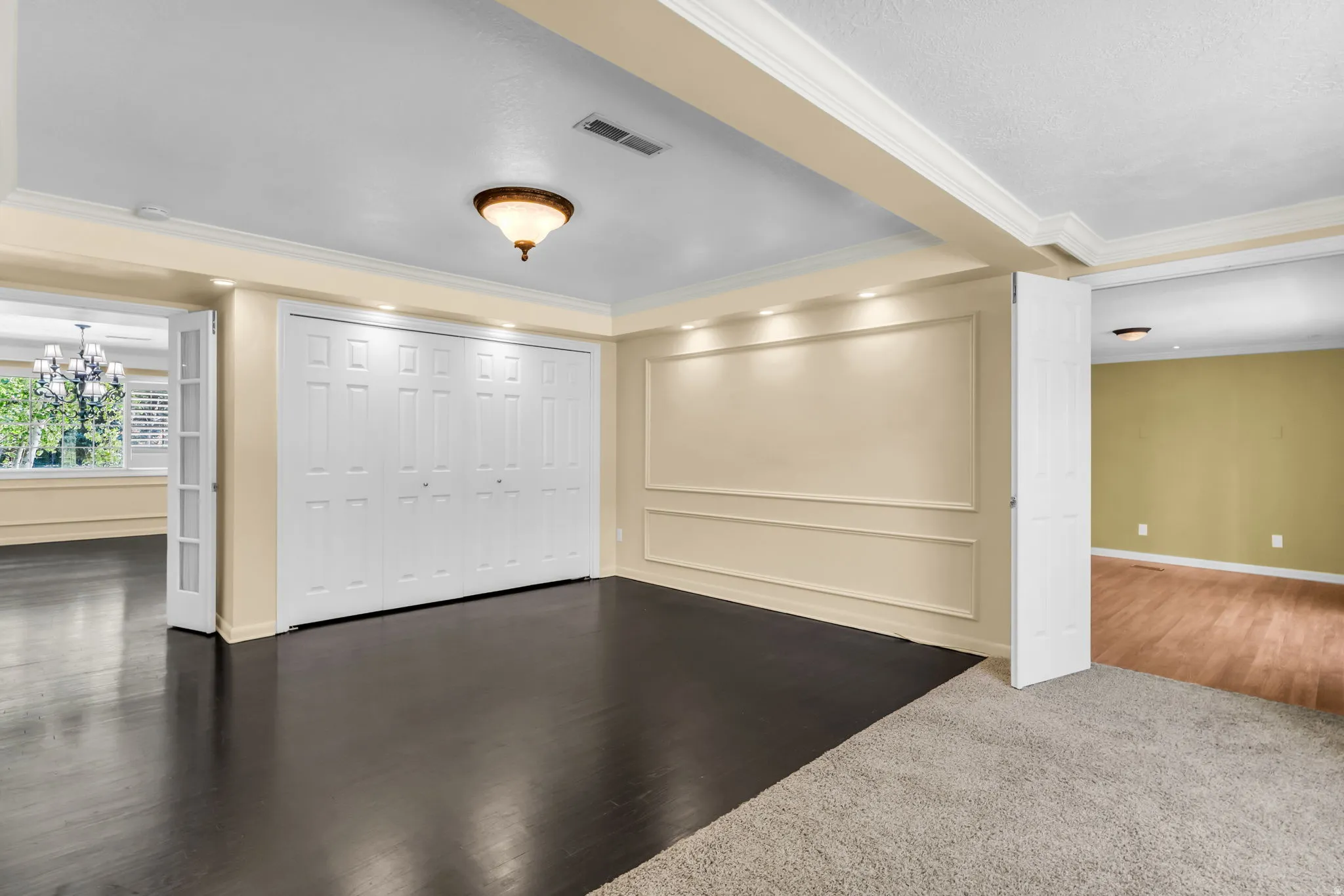 Built-in bi-fold closet, recessed lighting, wood-finish flooring, crown molding, and wall molding