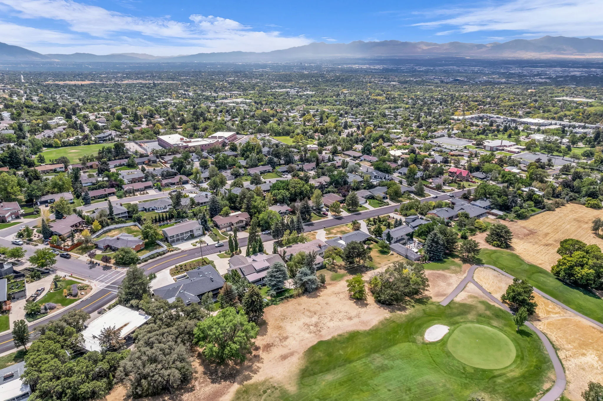 Expansive residential area with mature trees and a golf course