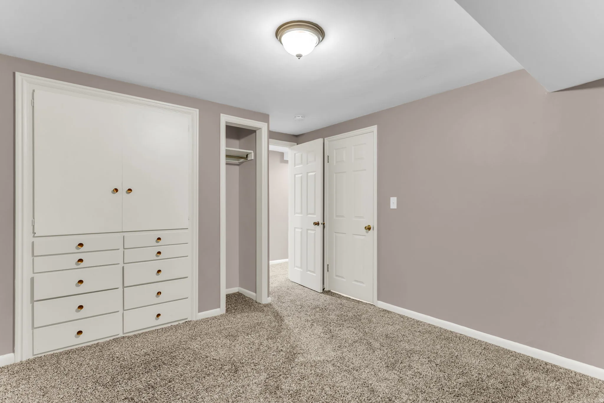 Built-in cabinetry with drawers, neutral wall finish, and flush-mount lighting