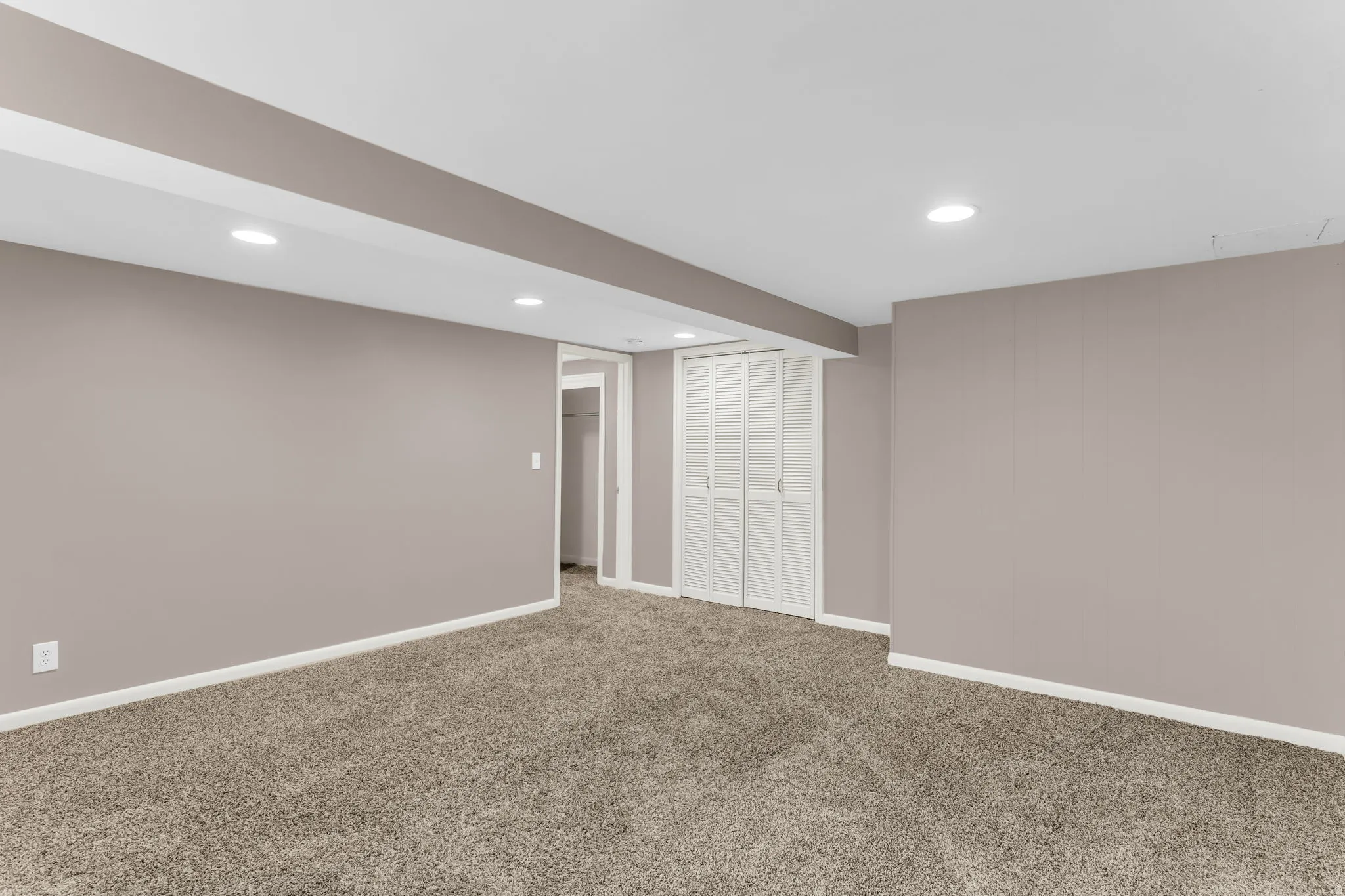 Recessed lighting, neutral wall tones, white trim, carpeted flooring, and white louvered bifold doors
