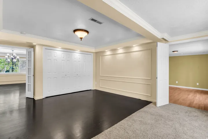 Built-in bi-fold closet, recessed lighting, wood-finish flooring, crown molding, and wall molding