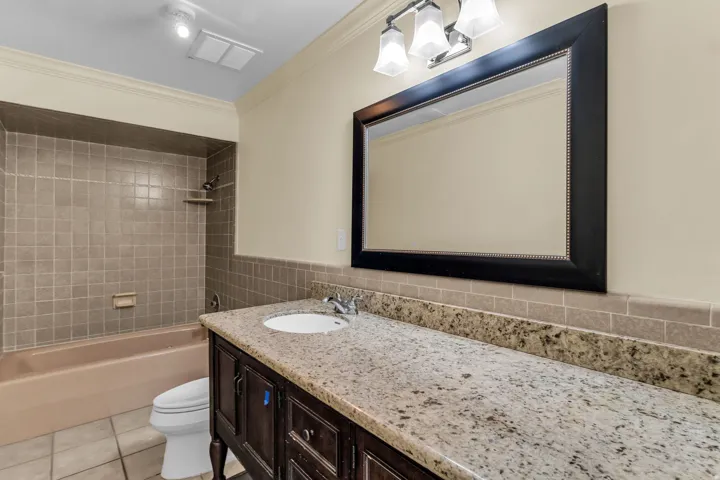 Vanity with a light-toned countertop, integrated sink, and dark wood-finish cabinetry