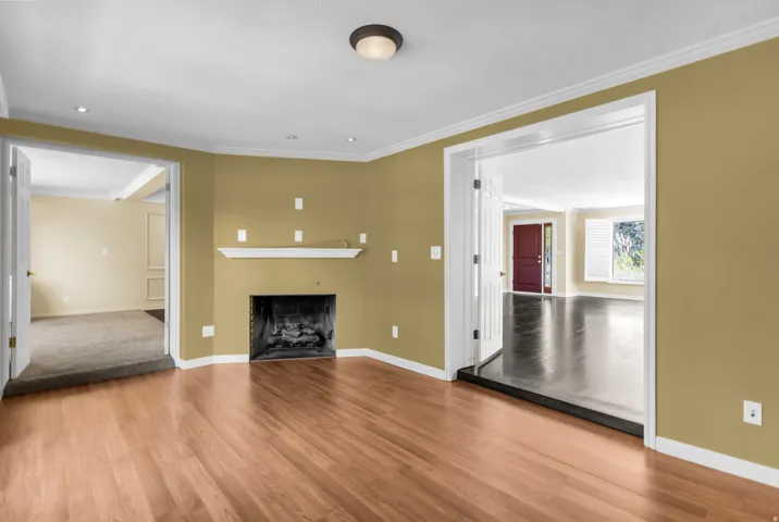 Hardwood flooring, recessed lighting, built-in fireplace, crown molding, and a solid core door