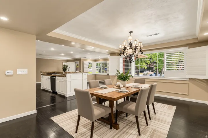 Hardwood flooring, recessed lighting, crown molding, white kitchen cabinetry, and plantation shutters
