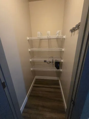Built-in wire shelving, wood-finish flooring, and light-toned wall paint