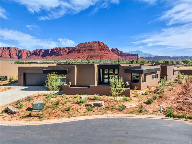 Contemporary exterior with a flat roof, integrated garage, and a modern entry door