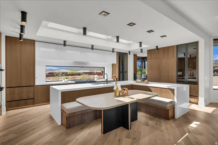 Kitchen featuring wood-finish cabinetry, integrated appliances, and a built-in banquette