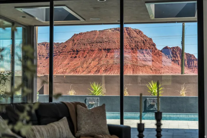 Floor-to-ceiling windows frame dramatic red rock formations and desert landscape vistas