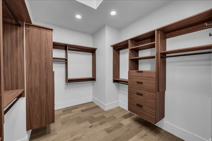 Custom closet system featuring wood-finish cabinetry, integrated shelving, and multiple hanging rods