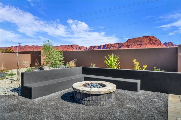 Built-in perimeter seating, a stone-clad circular fire pit, and a gravel-covered outdoor space