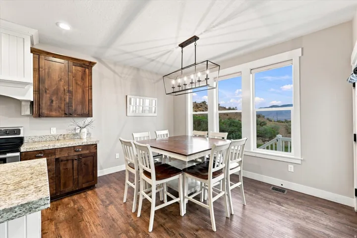 Wood-finish flooring, recessed lighting, and a linear chandelier illuminate this space