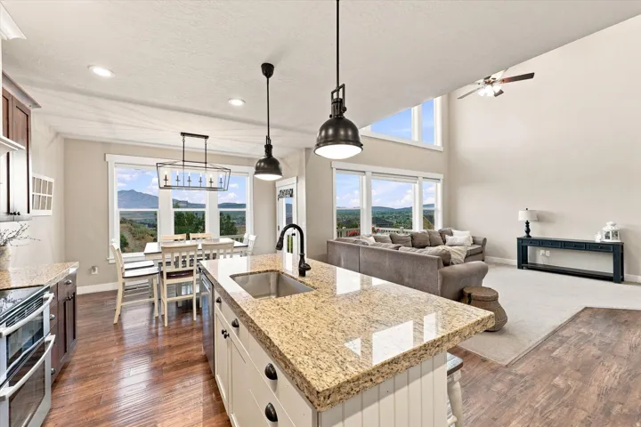 Kitchen island with granite-finish countertop, stainless steel sink, and matte black faucet
