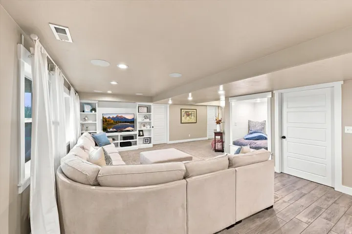 Built-in media center with shelving, recessed lighting, and wood-finish flooring