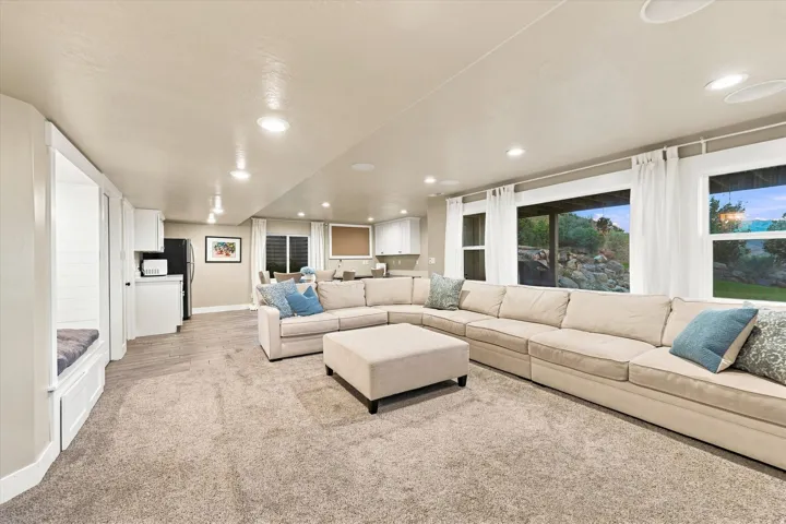 Expansive living area with recessed lighting, large windows, wood-finish flooring, and built-in cabinetry