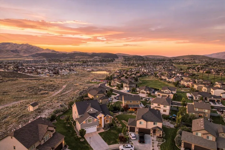 Expansive residential community featuring a variety of single-family homes with established landscaping, paved streets, and a mountainous backdrop