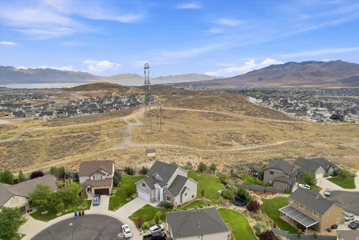 Expansive neighborhood with a partial water body visible in the distance and surrounding mountain backdrop