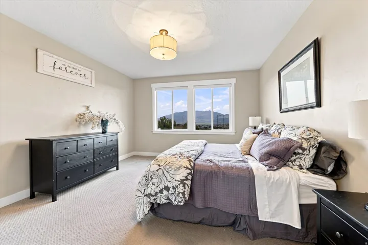Recessed lighting, carpeted flooring, and a large window with a distant mountain backdrop
