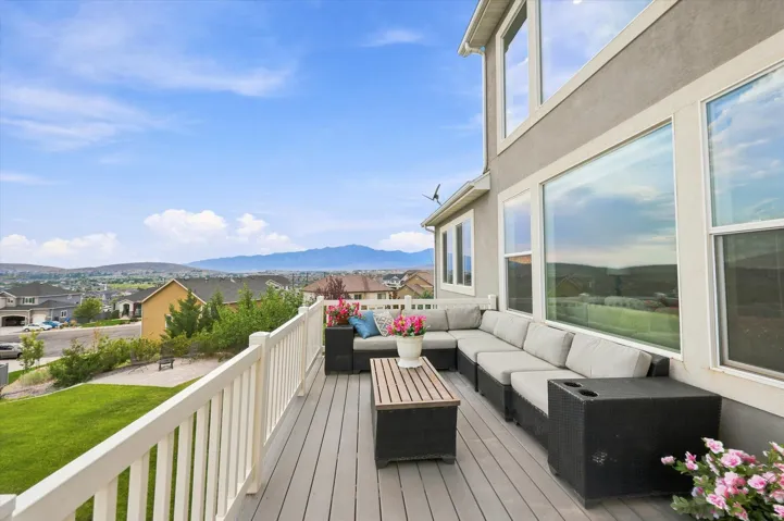 Exterior deck with composite decking, white railing, and multiple large windows