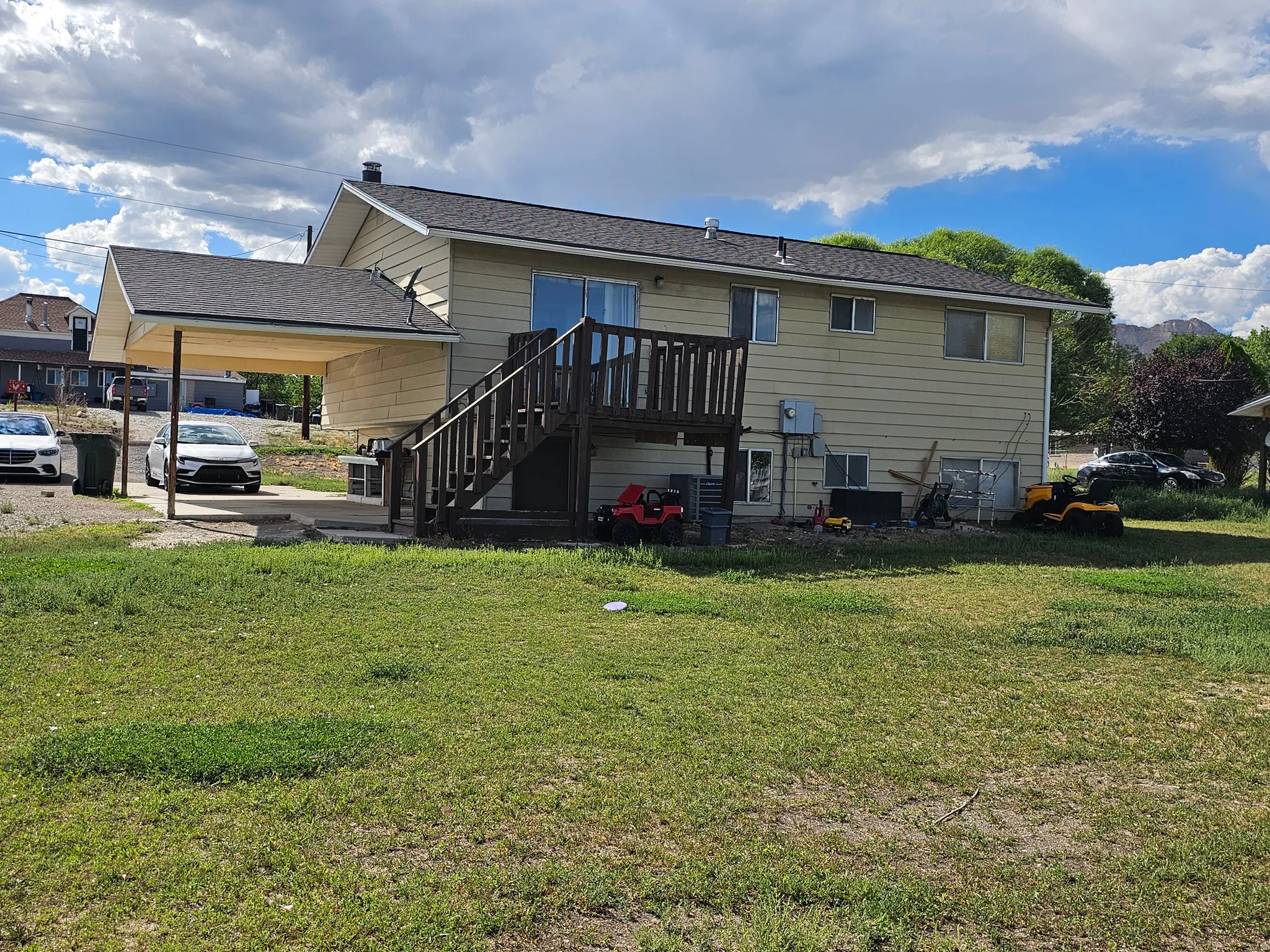 Spacious elevated home with composite deck, siding exterior, and expansive lawn