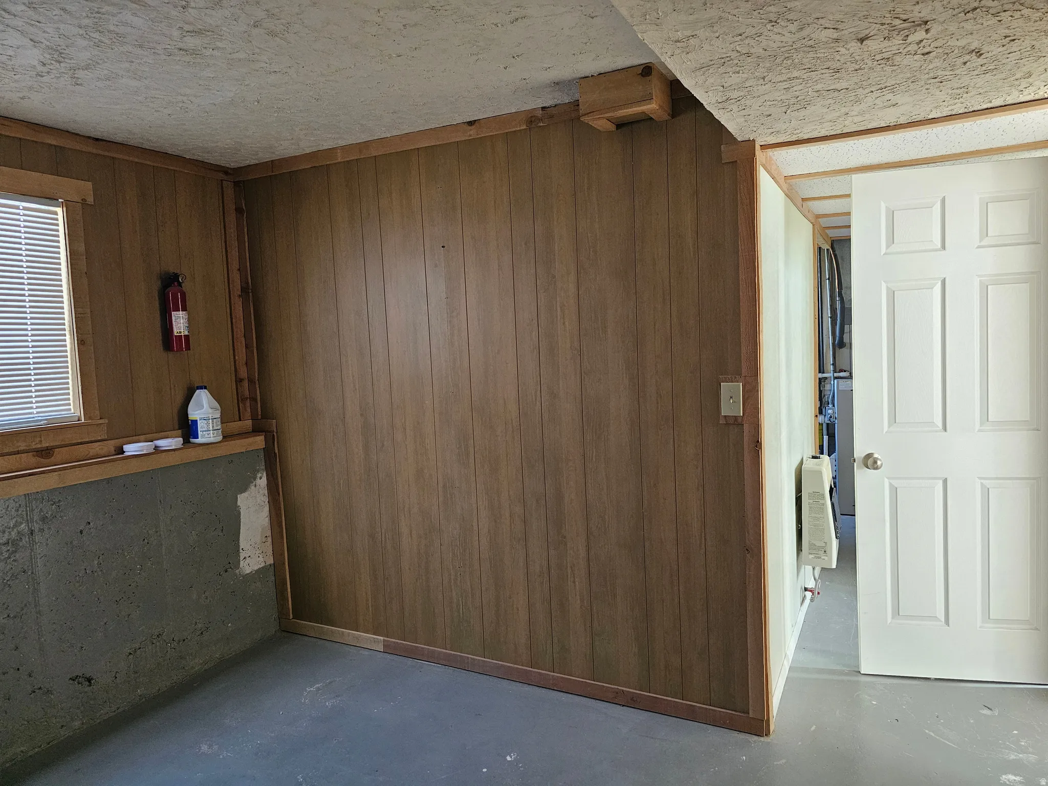 Paneling walls and concrete flooring with a white paneled door