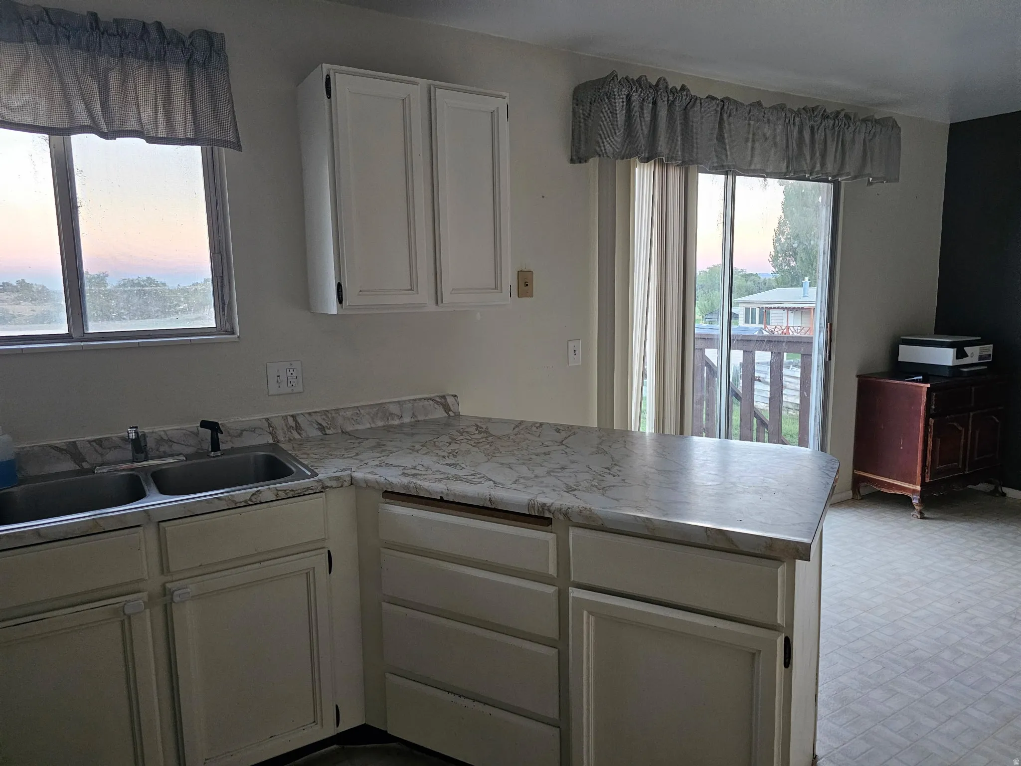 Kitchen featuring white cabinetry and a double basin sink