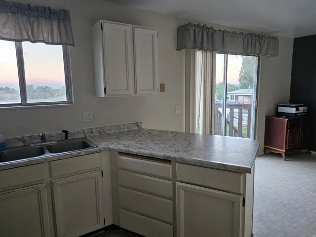 Kitchen featuring white cabinetry and a double basin sink