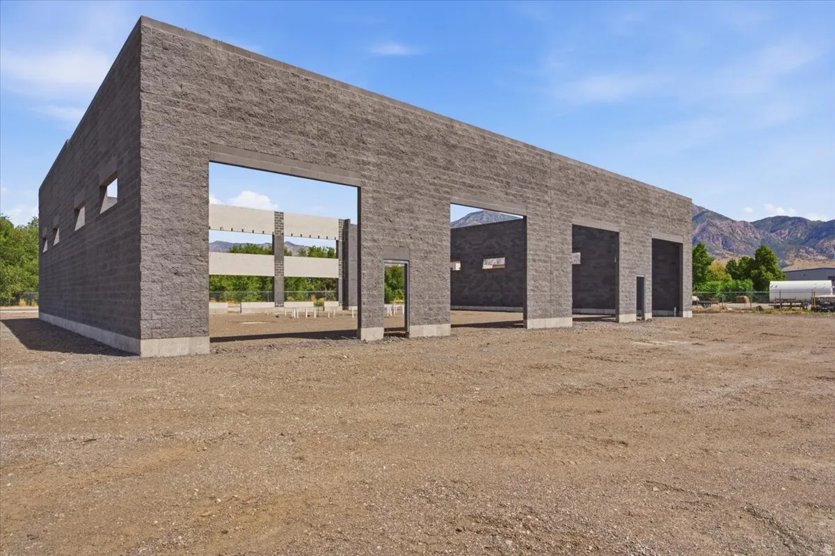 Concrete block exterior with multiple large openings and smaller rectangular windows