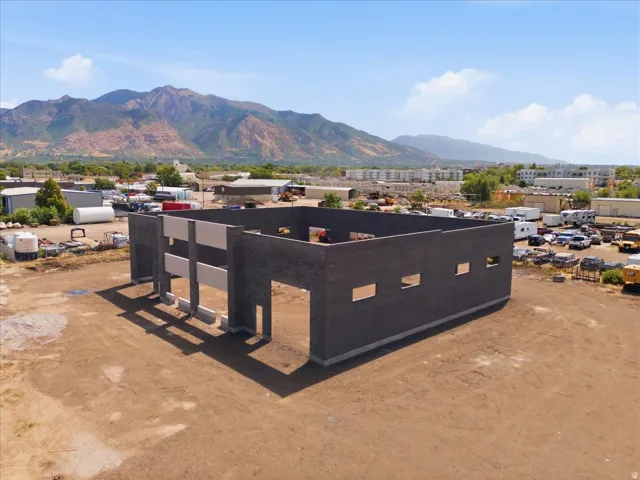 Pre-construction commercial structure featuring exposed block walls and a mountain backdrop