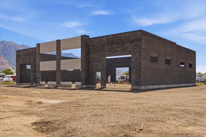 Concrete block construction featuring multiple large openings and inset rectangular windows