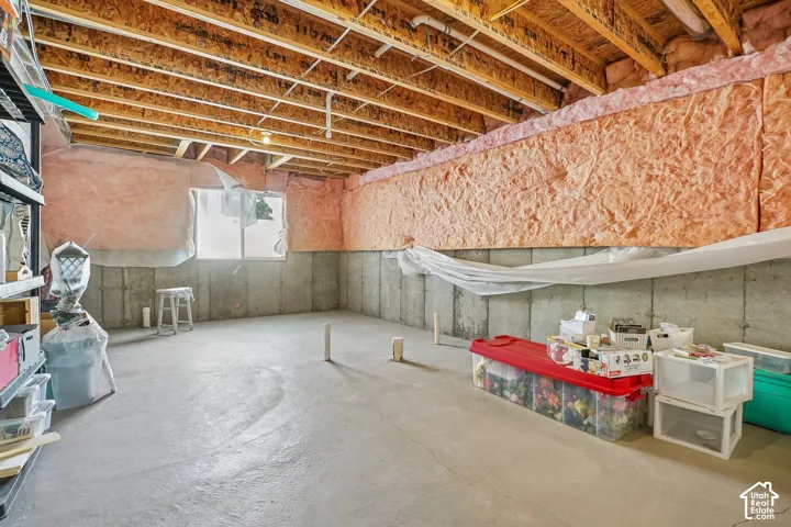 Concrete flooring with exposed ceiling joists and a single window