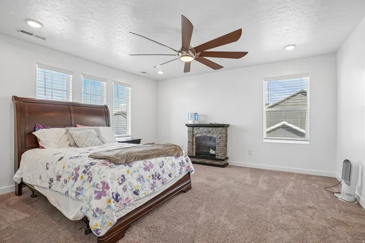 Recessed lighting, wood-finish ceiling fan, and multiple windows with blinds