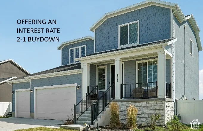 Two-story residence featuring blue shake and lap siding, stone veneer accents, a covered front porch with metal railing, and an attached three-car garage