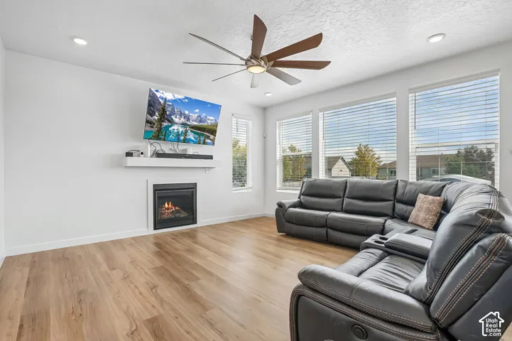 Wood-finish flooring, recessed lighting, and a ceiling fan