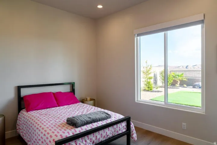 Recessed ceiling lighting, wood-finish flooring, full-height window, backyard access, and mountain backdrop