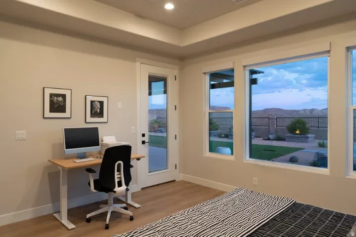 Recessed lighting, tray ceiling, full-light exterior door, multiple large windows, wood-finish flooring